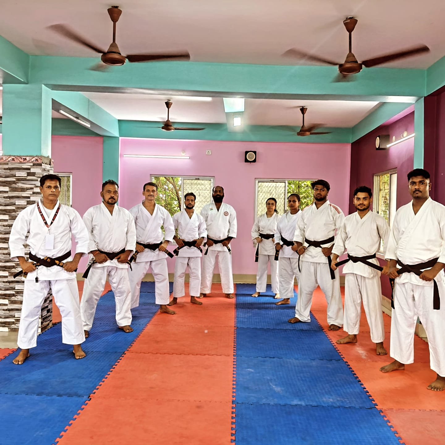 Black belt candidates and instructors standing in formation, fists ready