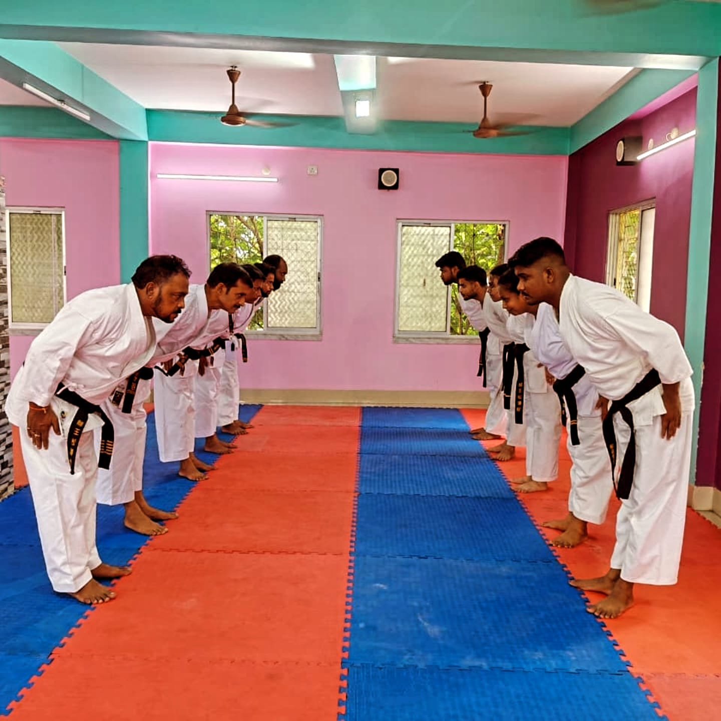 Students seated on the mat taking the written black belt exam